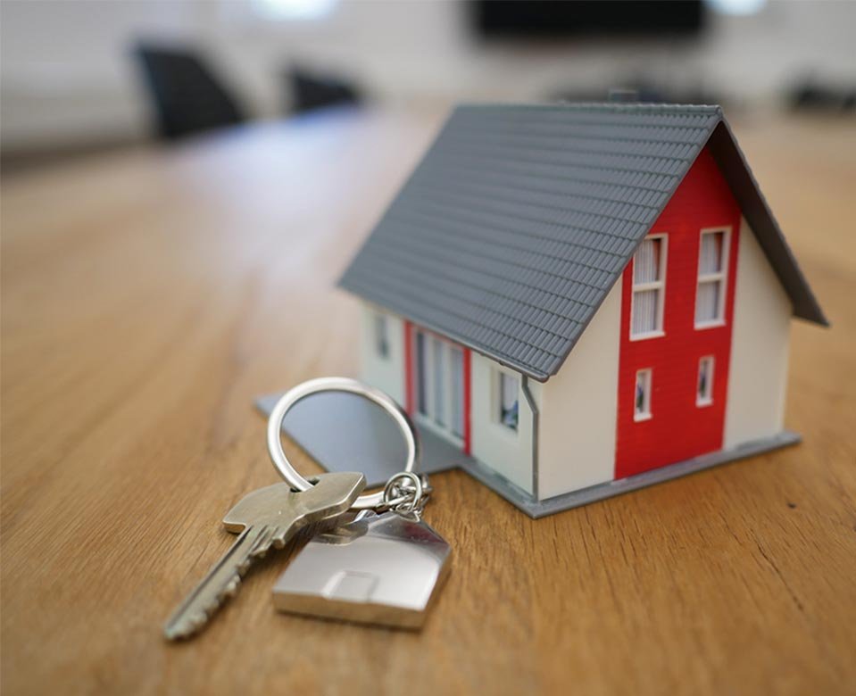 Un modelo miniatura de una casa en vente en puebla con unas llaves a un lado.